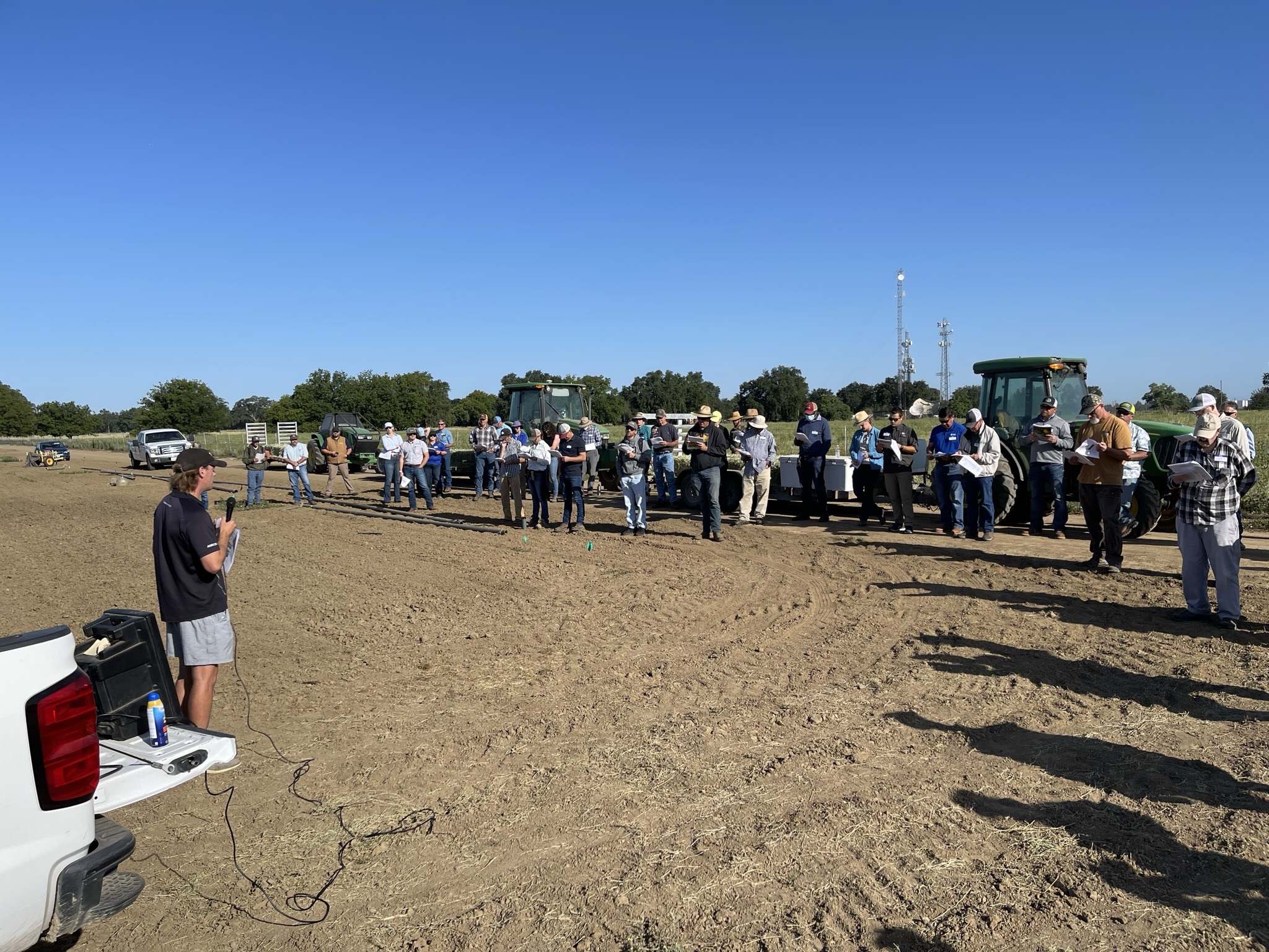 audience members reading handouts while listening to alfalfa field day presentation