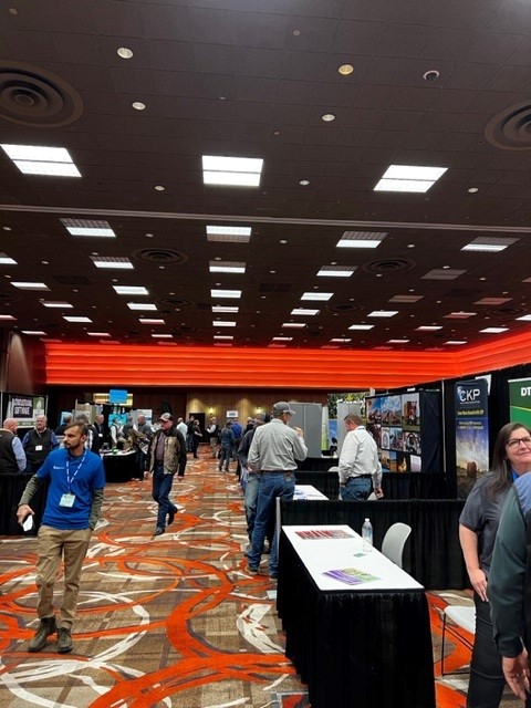The exhibit hall with milling around the tables