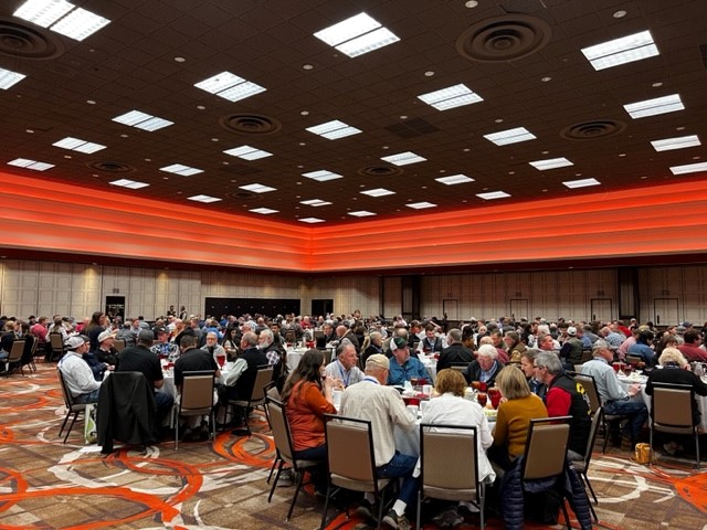 The Symposium attendees sitting eating lunch and mingling