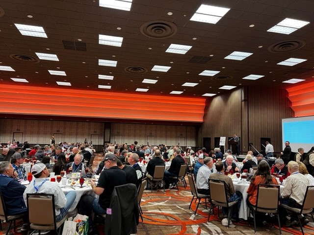 The Symposium attendees sitting eating lunch and mingling