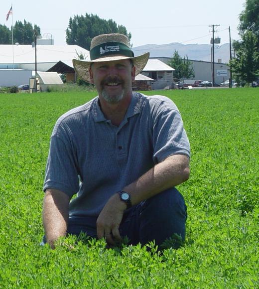 dan putnam kneeling in a field in tulelake